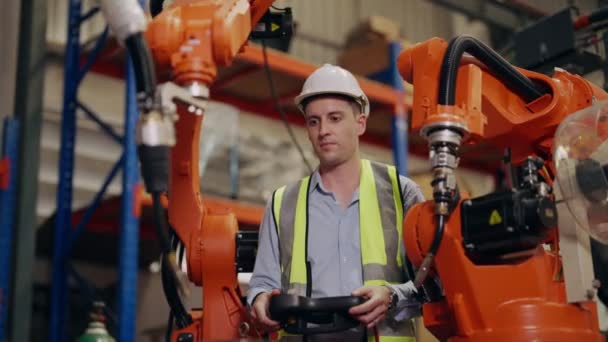 工業生産工場で働く安全均一な保護を持つ産業技術者労働者 倉庫でのロボット機械のチェックと制御技術者 エンジニアリングコンセプト — ストック動画