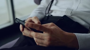 Cep telefonuyla konuşan, teknolojiyle rahatlayan, restoranda akıllı telefon oynayan genç bir adamın ekranlara dokunuşunu kapatın. 