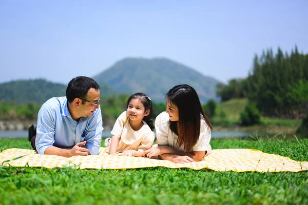 Happy family relaxing and playing outdoor together in park on weekend, Cheerful family father mother and children enjoying picnic at park, Parents travel with daughter and son in nature, Family with