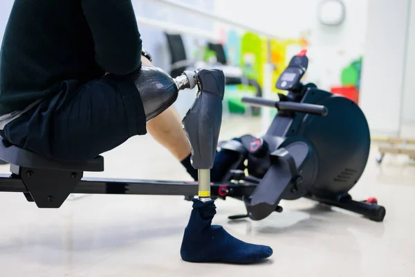 Disabled sporty man exercising with prosthetic leg at gym, People with high tech technology at prosthetic manufacturing, New artificial limb production for disabled people