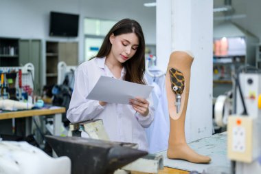 Protez bacağı tutan profesyonel protez teknisyen. Laboratuvarda çalışıyor ve kalitesini kontrol ediyor. Protez üretiminde yüksek teknoloji kullanan geliştirme mühendisi.