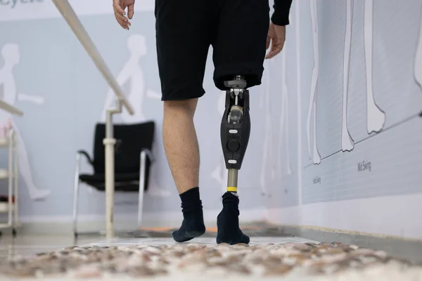 Nurse training male patient walking in physical therapy session, Patient with high tech technology at prosthetic manufacturing, New artificial limb production for disabled people