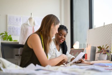 Moda tasarımcısının mutlu çifti atölyede birlikte çalışıyor, kadın terzi ölçü ve kıyafet provaları yapıyor, manken giyimi atölyesinde terzilik yapıyor.