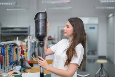 Protez bacak kontrolü yapan ve laboratuvarda çalışan genç bayan teknisyen, protez üretiminde yüksek teknoloji uzmanı, engelliler için yeni yapay uzuv üretimi