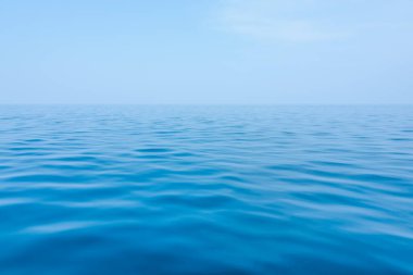 Yumuşak dalgalı mavi deniz ve denizle aynı renkte bir gökyüzü. Göze hoş gelen küçük dalgalarla dolu huzurlu bir okyanus. Yüksek kalite fotoğraf