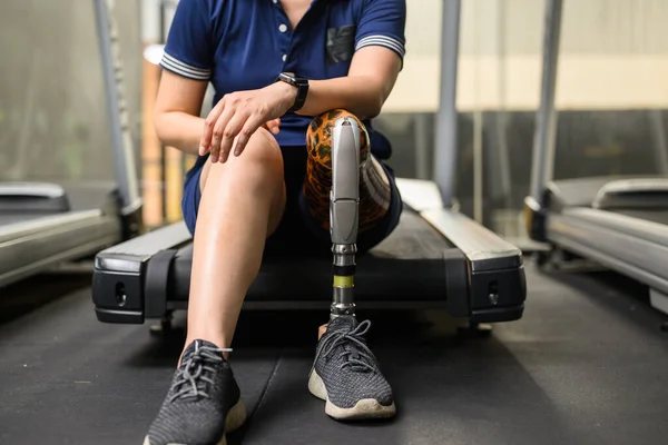 Disabled athlete patient with prosthetic leg doing exercise at gym, People with physical disability, High tech technology at prosthetic health care center, New artificial limb for disabled people