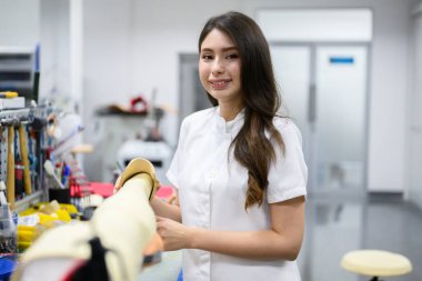 Protez bacak kontrolü yapan ve laboratuvarda çalışan genç bayan teknisyen, protez üretiminde yüksek teknoloji uzmanı, engelliler için yeni yapay uzuv üretimi