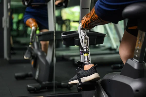 Disabled athlete patient with prosthetic leg doing exercise at gym, People with physical disability, High tech technology at prosthetic health care center, New artificial limb for disabled people