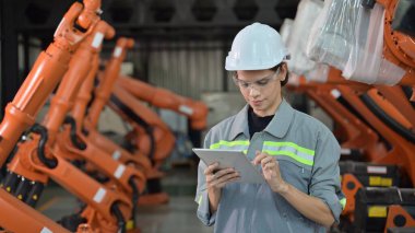 Fabrikada robot makine otomasyonuyla çalışan bakım mühendisi, endüstride akıllı teknolojili kadın teknisyen, robot makinenin parçalarını kontrol eden ve kontrol eden kadın işçi.