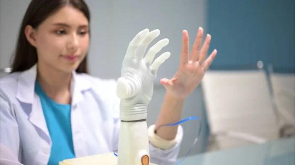 Professional technician testing robotic bionic arm at prosthetic manufacturing, Technician checking and controlling artificial prosthetic hand, Technology at prosthetic manufacturing