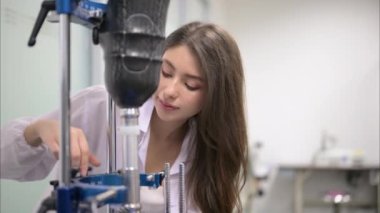 Protez bacak kontrolü yapan ve laboratuvarda çalışan genç bayan teknisyen, protez üretiminde yüksek teknoloji uzmanı, engelliler için yeni yapay uzuv üretimi
