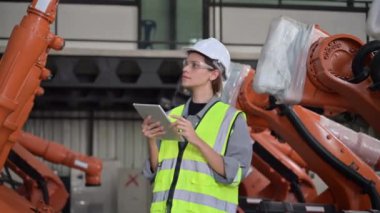 Fabrikada robot makine otomasyonuyla çalışan bakım mühendisi, endüstride akıllı teknolojili kadın teknisyen, robot makinenin parçalarını kontrol eden ve kontrol eden kadın işçi.