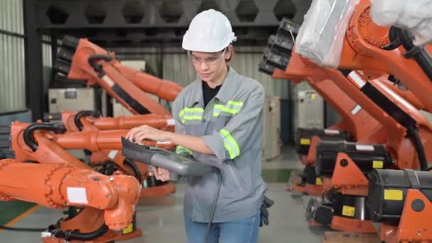 工場でロボット機械自動化に取り組むメンテナンスエンジニア労働者 業界でスマートテクノロジーを活用する女性技術者 ロボット機械の部品のチェックと制御を行う女性労働者 — ストック動画