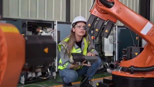 工場でロボット機械自動化に取り組むメンテナンスエンジニア労働者 業界でスマートテクノロジーを活用する女性技術者 ロボット機械の部品のチェックと制御を行う女性労働者 — ストック動画