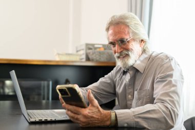 Senior grandfather using laptop and smart phone at home, Happy retirement people relaxing and resting at home, Healthy and happy senior people concept