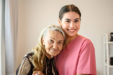 Doktor ya da hemşire evde ya da huzurevinde kıdemli bir hastayla, steteskopu olan profesyonel bir kadın doktorla, ev ziyareti sırasında doktor ve yaşlı bir kadınla konuşuyor.