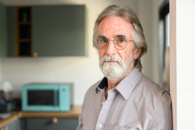 Gözlüklü mutlu son sınıf öğrencisi, kamera fotoğrafına bakıyor büyükbaba evde dinleniyor ve dinleniyor, mutlu emekli adam evde.