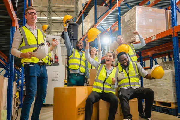 Group of happy warehouse workers celebrating success in warehouse factory, Cheerful workers having fun at work, Happiness at job, Concept of success, Happy team enjoying their successful job