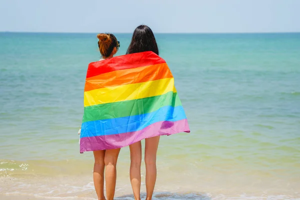 Pareja Mujeres Alegres Con Bandera Del Arco Iris Pie Playa — Foto de Stock