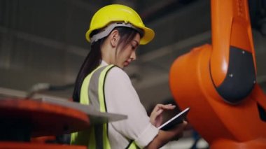 Endüstriyel depo fabrikasında çalışan kadın endüstriyel mühendis elinde tablet, teknisyen depoda robot makineleri kontrol ve onarım, mühendislik konsepti