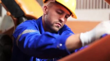 Endüstriyel fabrikada makine robotik silahlarıyla çalışan profesyonel mühendisler, makine ve bakım robotlarının güvenliğini kontrol eden teknisyenler, makineleri kontrol eden ve kontrol eden mühendisler,
