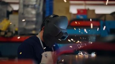 Endüstriyel fabrikada kaynak yapan çelik, metal parçaları kaynak yapan güvenlik maskesi takan işçi imalat fabrikasında çalışan sanayi teknisyeni depoda robot makineleri tamir eden sanayi teknisyeni.