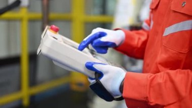 Endüstriyel santralde programlama kurmak için makine üzerinde çalışan ve çözen mühendisler, teknisyenler fabrika, teknoloji ve yenilikteki robotik makinelerin parçalarını kontrol edip onarıyorlar