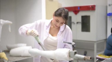 Protez fabrikasının genç teknisyeni atölyede protez cihazı tamir ediyor, ortopedist protez parçasını laboratuvarda kontrol ediyor, yüksek teknoloji alanında uzman.