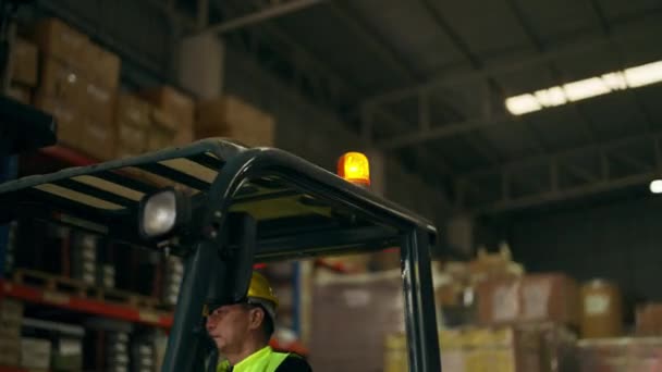 仓库工人在工厂从事叉车工作 高级叉车司机戴黄色头盔驾驶叉车去仓库工作 工业工程师在工厂工作 — 图库视频影像