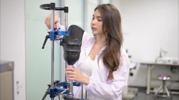持有假肢检查并在实验室工作的年轻女性技师 假肢制造方面的高科技专家 残疾人新假肢生产专家 — 图库视频影像