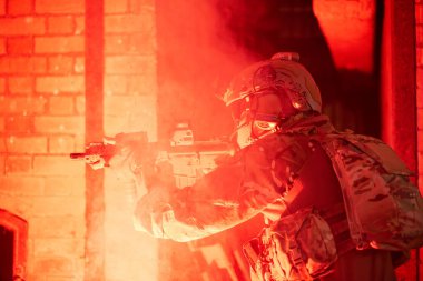 Uzman askerler askeri harekat sırasında düşmana saldırıyor. Koruyucu savaş üniformalı askerler, savaş meydanında tüfekli askerler.