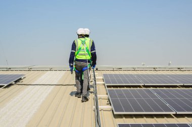 Güneş enerjisi tarlasında güvenlik kaskı olan profesyonel mühendisler, enerji fabrikasının çatısında güneş pili olan teknisyenler, sürdürülebilir kaynak kavramı