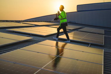 Akşamları günbatımında güneş enerjisi, sıcak gökyüzünde güneş enerjisi, temiz enerji ve alternatif enerji ile çalışan mühendis.