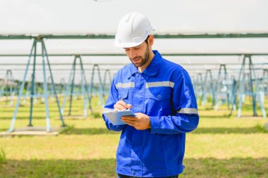 Güneş pili çiftliğine güneş panelleri kuran teknisyen, elektrik santralinde çalışan mühendis, güneş panelleri alanında elektrik sistemi bakımı, çevre dostu ve temiz enerji