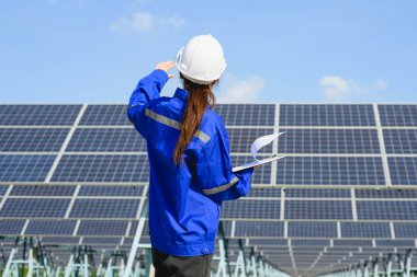 Güneş enerjisi çiftliğinde çalışan kadın mühendis, güneş pillerini analiz eden işçi, yenilenebilir enerji, yenilenebilir enerji üretimi ve sürdürülebilir kaynak