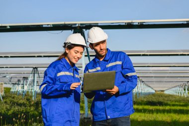 Endüstriyel güneş pili çiftliğine güneş panelleri kuran teknisyen ekibi, elektrik santralinde çalışan mühendisler, güneş panelleri alanında elektrik sistemi bakımı, çevre dostu ve temiz enerji