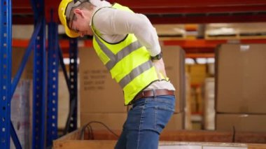 Male warehouse engineer manager suffering from back injury during checking stock working at warehouse factory, Storage worker having back pain at work