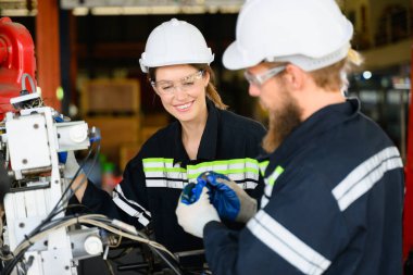 Makine mühendisleri fabrikadaki motor makinelerini tamir ediyor, imalat fabrikasındaki makineleri kontrol eden ve denetleyen işçiler, makine bakım konsepti, yapay zeka teknolojisi...