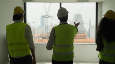 Group of professional civil engineers team working on new building at construction site, Contractor talking and assigning work to workers, Engineering and architecture concept