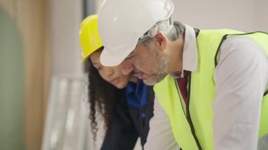 Professional construction engineers team using blueprint of project plan brainstorming and working together at construction building, Architecture and building construction concept