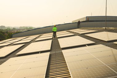 Akşamları günbatımında güneş enerjisi, sıcak gökyüzünde güneş enerjisi, temiz enerji ve alternatif enerji ile çalışan mühendis.