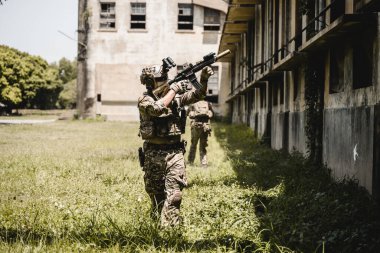 Askeri harekat sırasında ileri doğru koşan ve düşmana saldıran askerlerden oluşan akıllı bir ekip. Koruyucu savaş üniformalı askerler, tüfekli askerler, savaş meydanında tüfekli askerler.