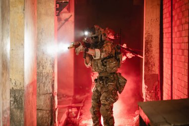 Uzman askerler askeri harekat sırasında düşmana saldırıyor. Koruyucu savaş üniformalı askerler, savaş meydanında tüfekli askerler.