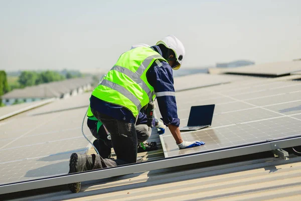 太陽光発電所の太陽光発電システムをチェックする安全ヘルメットを持つプロのエンジニア 発電所の屋根に太陽電池を持つ技術者 持続可能な資源の概念 — ストック写真