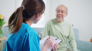 Young doctor examining senior patient at home visit, Senior man consulting medicine with pharmacist, Caregiver nurse taking care of elderly grandfather sitting on sofa at home, Medical service concept