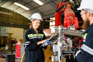 Makine mühendisleri fabrikadaki motor makinelerini tamir ediyor, imalat fabrikasındaki makineleri kontrol eden ve denetleyen işçiler, makine bakım konsepti, yapay zeka teknolojisi...