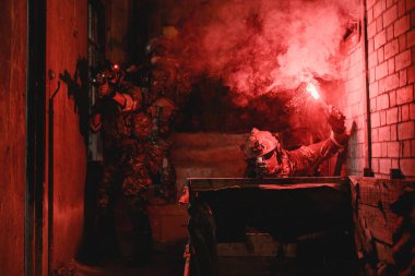 Uzman askerler askeri harekat sırasında düşmana saldırıyor. Koruyucu savaş üniformalı askerler, savaş meydanında tüfekli askerler.