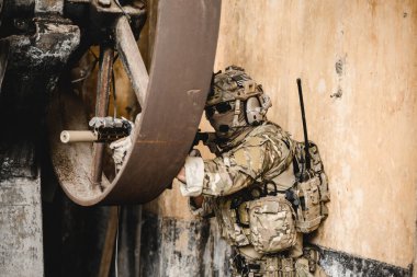 Uzman askerler askeri harekat sırasında düşmana saldırıyor. Koruyucu savaş üniformalı askerler, savaş meydanında tüfekli askerler.