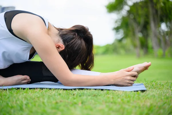 Genç bir kadının yaşam tarzı parkta yoga yapıyor. Parkın dışındaki Yoga 'da. Yüksek kalite fotoğraf