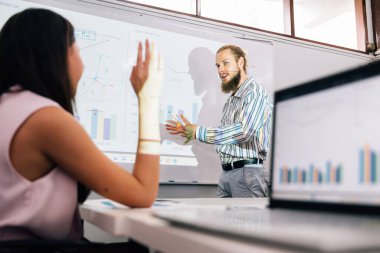 Bir grup profesyonel iş adamı modern ofiste toplanıp brifing veriyor, grafik grafikli işadamları verileri analiz ediyor ve iş projelerini planlıyorlar.